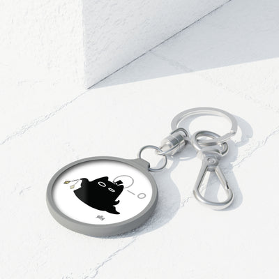 Lord of the Mysteries Cat Keyring - Black cat with monocle design, angled view on marble surface